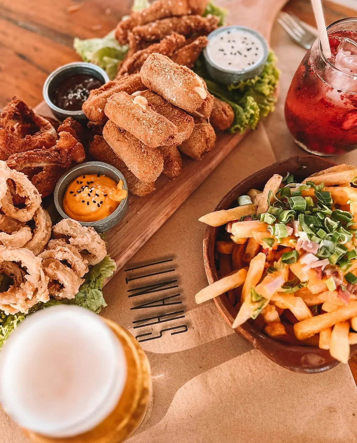 Una mesa de SHANTI con bocados, papas y salsas.