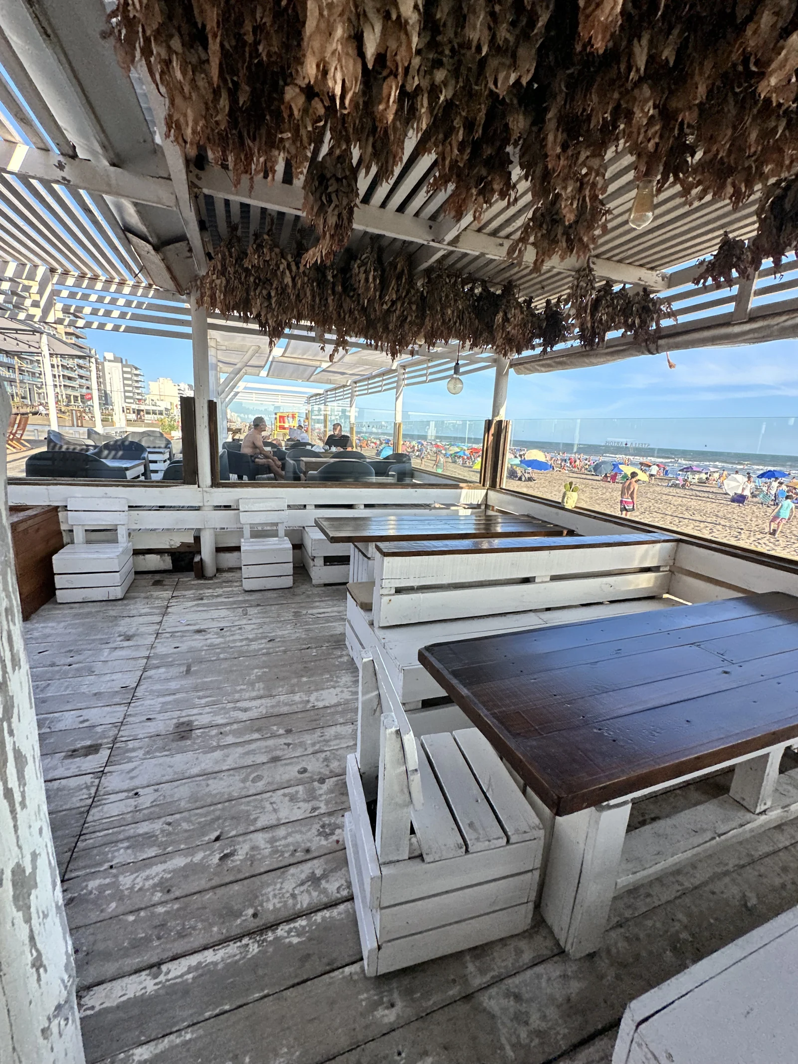 Mesas de madera del archivo SHANTI, bajo la pérgola y abiertas al mar.